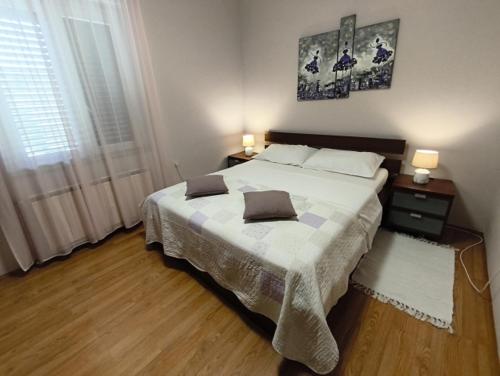 a bedroom with a large bed with two pillows on it at Apartman Maledi in Baška