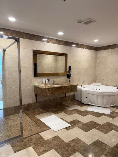 a bathroom with a tub and a sink and a shower at Karam Al Balad Hotel in Jeddah