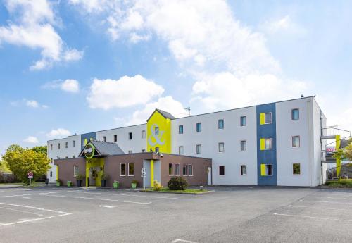 a white building with yellow and blue at B&B HOTEL Rennes Est Cesson Sévigné 3 étoiles in Cesson-Sévigné