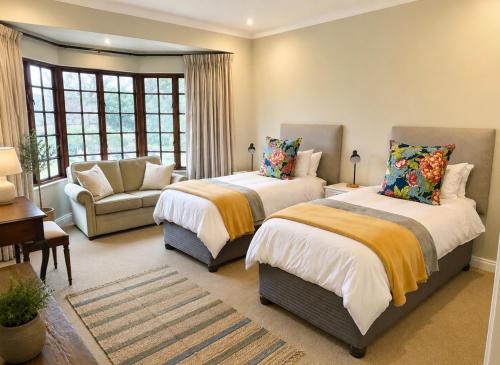 a bedroom with two beds and a couch at Bourne View in Nottingham Road