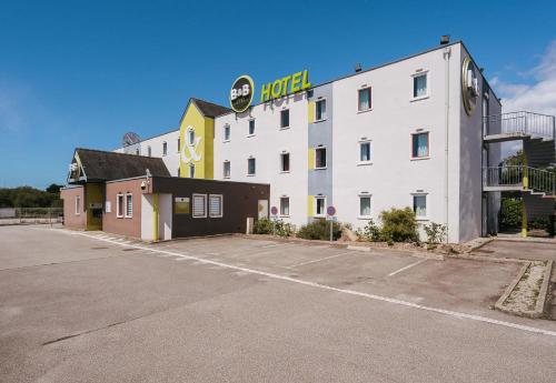 a large white building with a hotel sign on it at B&B HOTEL Lorient Caudan in Caudan