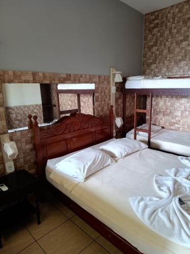 two beds in a room with two bunk beds at Pousada Campo Alegre Eireli in Itatiaia