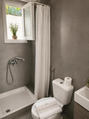 a bathroom with a toilet and a tub and a sink at Novus seaview in Benitses