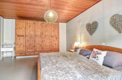 a bedroom with a bed and a wooden ceiling at Eifelraum-Relaxwohnung mit Sauna in Oberbettingen