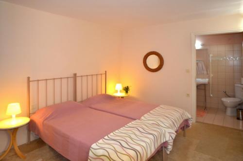 a bedroom with a bed and a bathroom with a toilet at Villa Verde Petra in Arménoi