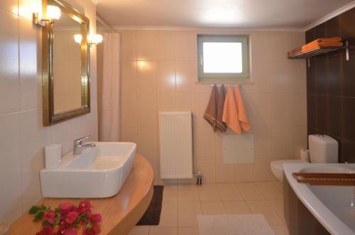 a white bathroom with a sink and a toilet at Villa Verde Petra in Arménoi