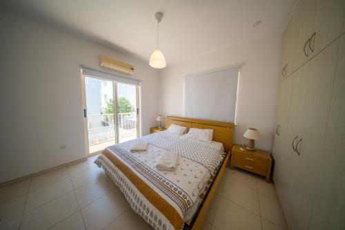 a bedroom with a bed and a large window at La Villa - Protaras in Paralimni