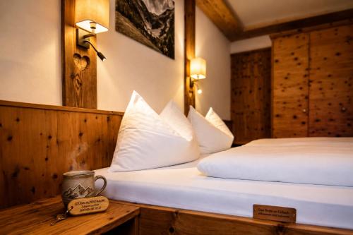 a hotel room with two beds with white pillows at Haus Alpenkönig Exclusive Apartments near Stubai Glacier in Neustift im Stubaital