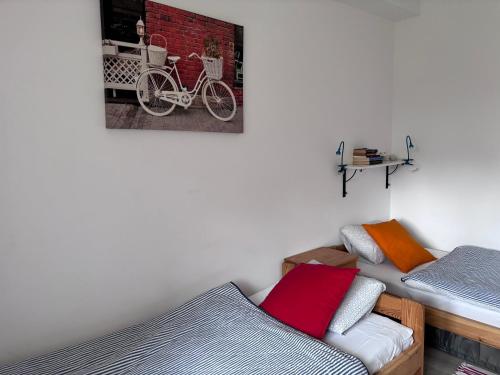 a bedroom with two beds and a picture of a bike on the wall at Apartamenty Nadmorska in Rowy