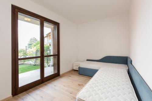 a bedroom with a bed and a large window at Residence Borgo Castello B1 Apartment in Argegno