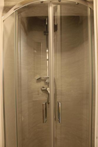 a shower with a glass door in a bathroom at Litharaki Guest House in Ano Syros