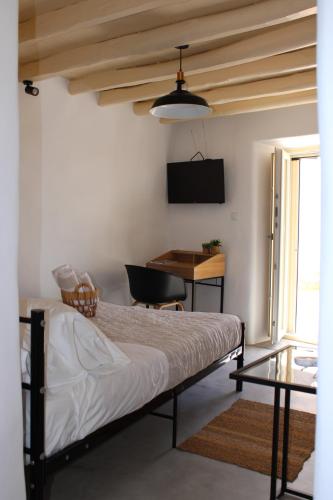 a bedroom with a bed and a desk and a table at Litharaki Guest House in Ano Syros
