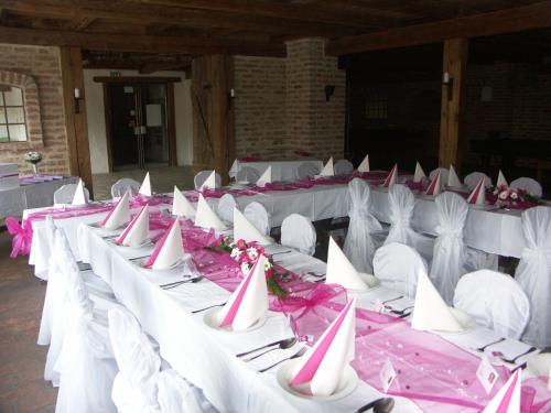a row of white tables with pink and white chairs at Hotel Stara Skola in Sloup