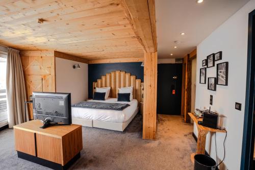 a bedroom with a bed and a television in it at Fahrenheit Seven Val Thorens in Val Thorens