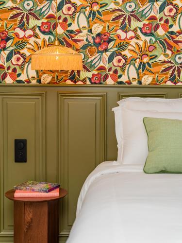 a bedroom with a bed and a floral wallpaper at Capucines Hotel Saint Tropez in Saint-Tropez