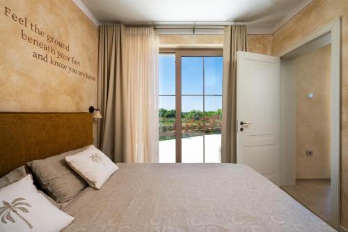 a bedroom with a bed and a large window at Villa Da Ella by IstriaLux in Krnica