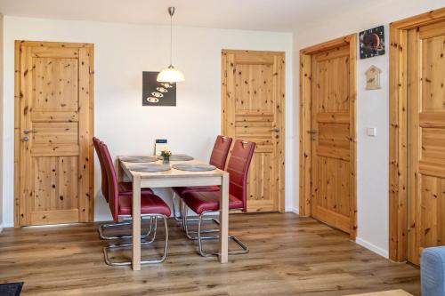 a dining room with a table and red chairs at Ferienhaus Saturn im Sternenpark in Lochow