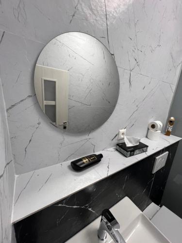 a bathroom with a sink and a mirror on the wall at Centrum Apartman LEYLA 7 in Bardejov