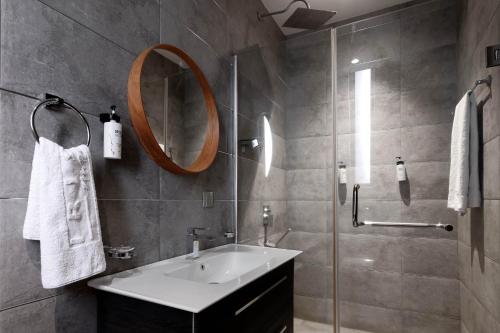 a bathroom with a sink and a mirror at Yellow Trumpet Iris Maitama in Abuja