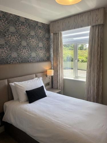 ein Schlafzimmer mit einem weißen Bett und einem Fenster in der Unterkunft Ring of Kerry Hotel in Cahersiveen