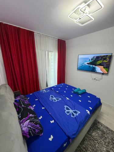 a bedroom with a bed with a blue comforter at Apartament in Ploiesti 8 in Ploieşti