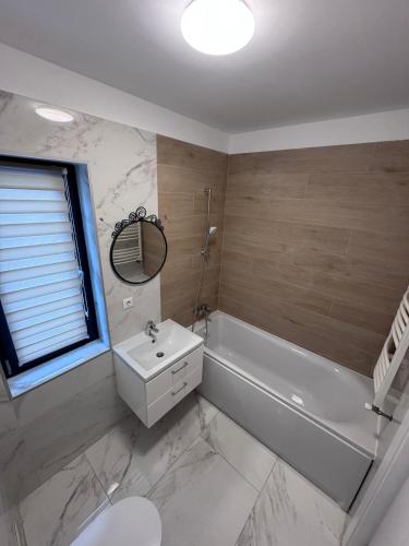 a bathroom with a white tub and a sink at Apartament in Ploiesti 8 in Ploieşti