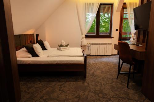 a bedroom with a bed and a desk and a computer at Zajazd U Dudziarza in Kościan