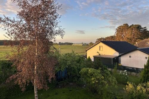 a small house and a tree in a field at Ruhige Auszeit zu zweit - Ferienwohnungen auf Usedom für Radfahrer & Strandliebhaber in Loddin