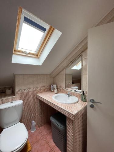 a bathroom with a toilet and a sink with a window at Quinta do Avô Brum in Flamengos