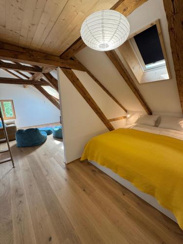 a bedroom with a yellow bed in a attic at Dachboden Loft in Laax