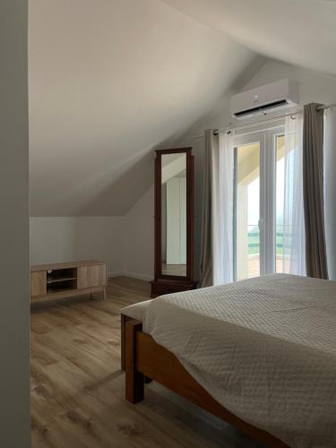 a bedroom with a bed and a mirror and a window at Quinta do Avô Brum in Flamengos