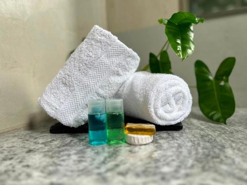 a pile of towels and a toothbrush and a glass at Blue Bird Hotels in Negombo