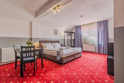 a bedroom with a bed and a desk and a chair at Casa Vlasin in Poiana Brasov