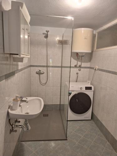 a bathroom with a sink and a washing machine at Studio Apartment Posavec in Premantura