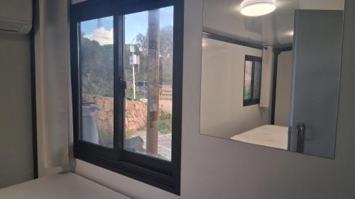 a mirror in a room with a window at Résidence Villa Smeralda in Telti