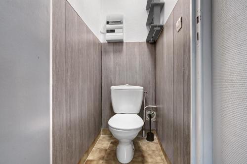 a bathroom with a white toilet in a room at 8.Les papillons option clim-4 pers in Calviac