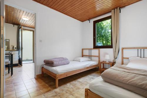 a bedroom with two beds and a bathroom with a sink at 8.Les papillons option clim-4 pers in Calviac