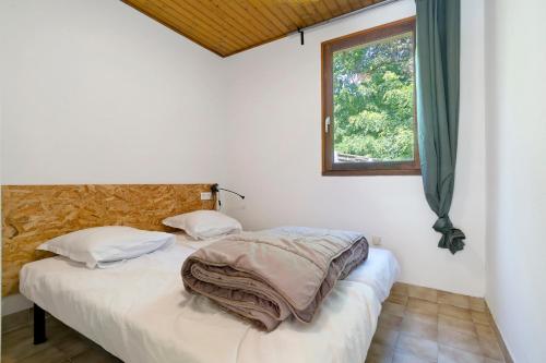 two twin beds in a room with a window at 15.La colline Clim.option- 6 pers in Calviac