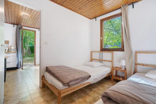 a bedroom with two beds and a kitchen with windows at 6.hirondelles Option Clim- 4 pers in Calviac
