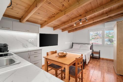 a kitchen with a table and a bed in a room at The Three Admirals in Pylos