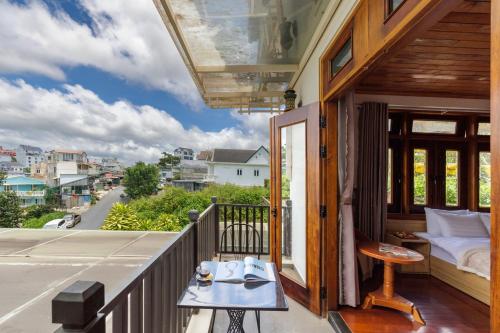 a balcony with a bed and a table at AT House Dalat - The Pine Concept in Da Lat