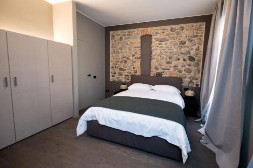 a bedroom with a large bed and a stone wall at Albergo Canzo in Canzo