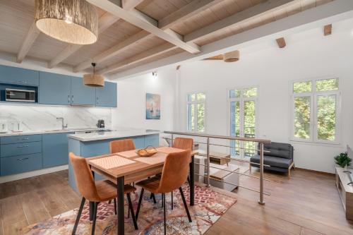 a kitchen with blue cabinets and a wooden table and chairs at The Three Admirals in Pylos