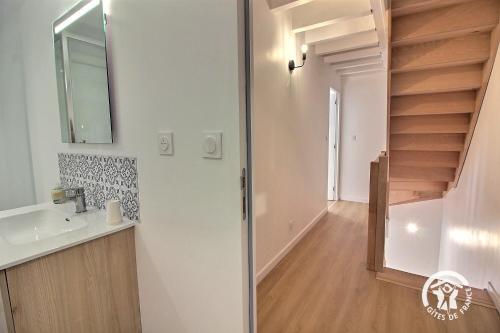 a bathroom with a sink and a mirror and stairs at Les pierres d'armor in Vildé-Guingalan