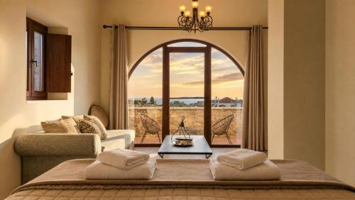 a living room with a bed and a large window at Areos Polis Boutique Hotel in Areopoli