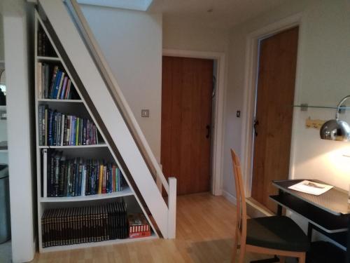a staircase with a book shelf filled with books at The Gate Cottage in West Itchenor