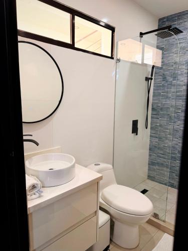 a bathroom with a toilet and a sink and a mirror at Bello apartamento con piscina cerca del mar in San Juan del Sur