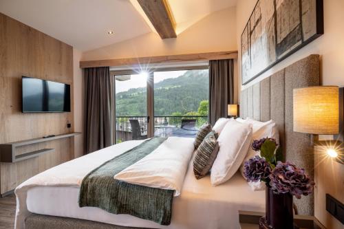 una camera da letto con un grande letto e una grande finestra di by franz - Alpine Apartments in Kirchberg a Kirchberg in Tirol