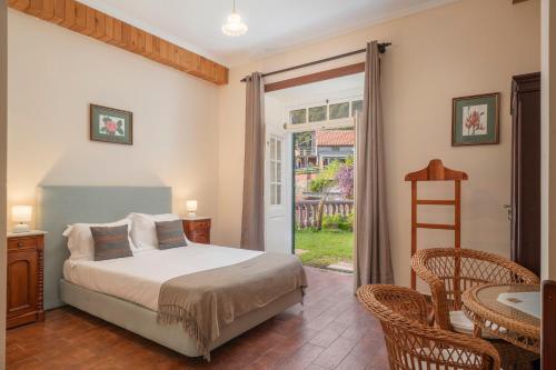 a bedroom with a bed and a sliding glass door at Casa da Fajã Alta in São Jorge