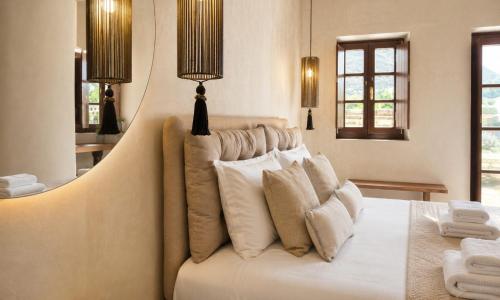 a bedroom with a large white bed with pillows at Areos Polis Boutique Hotel in Areopoli
